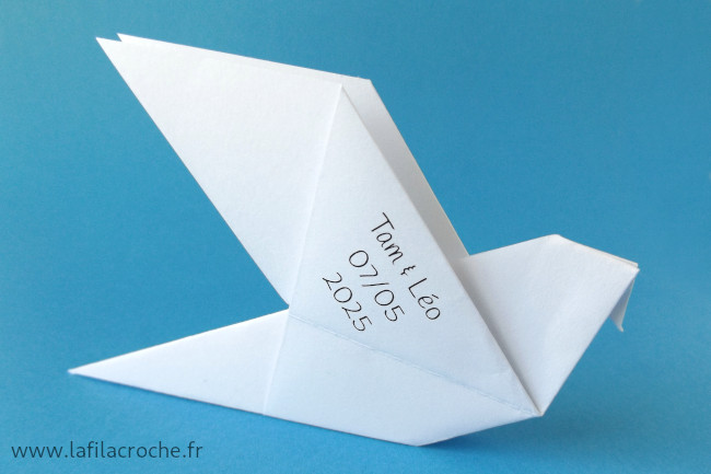 Un petit texte imprimé au verso d’un marque-place colombe origami