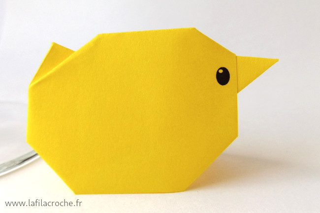 Marque-place poussin en origami avec le bec vers la droite