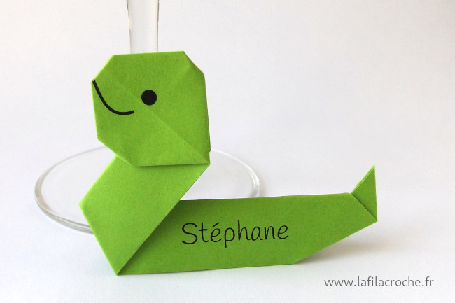 Un marque-place serpent en origami avec le prénome Stéphane imprimé sur son corps