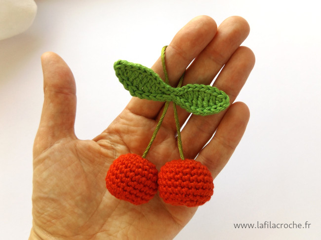 Charm cerises au crochet dans une main